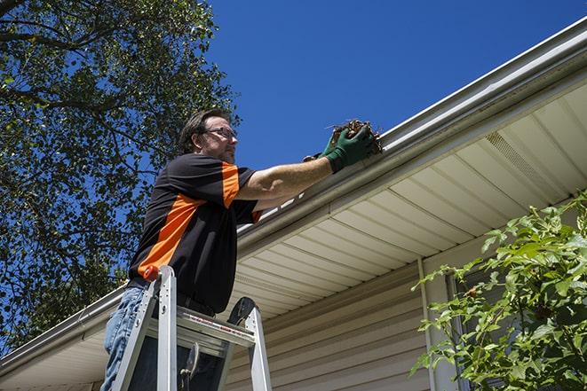 gutter repair specialist inspecting and fixing a damaged section in Altadena CA